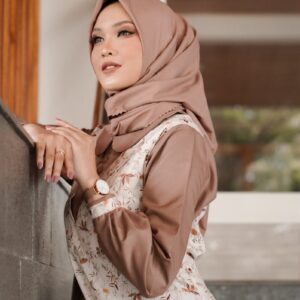 a woman in a hijab leaning against a wall